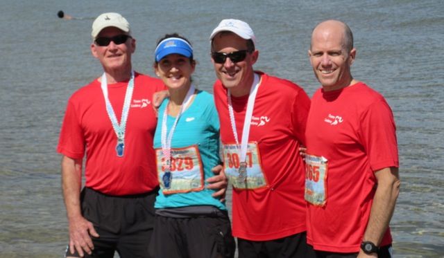 A picture of three men and a woman in athlete cloths. 