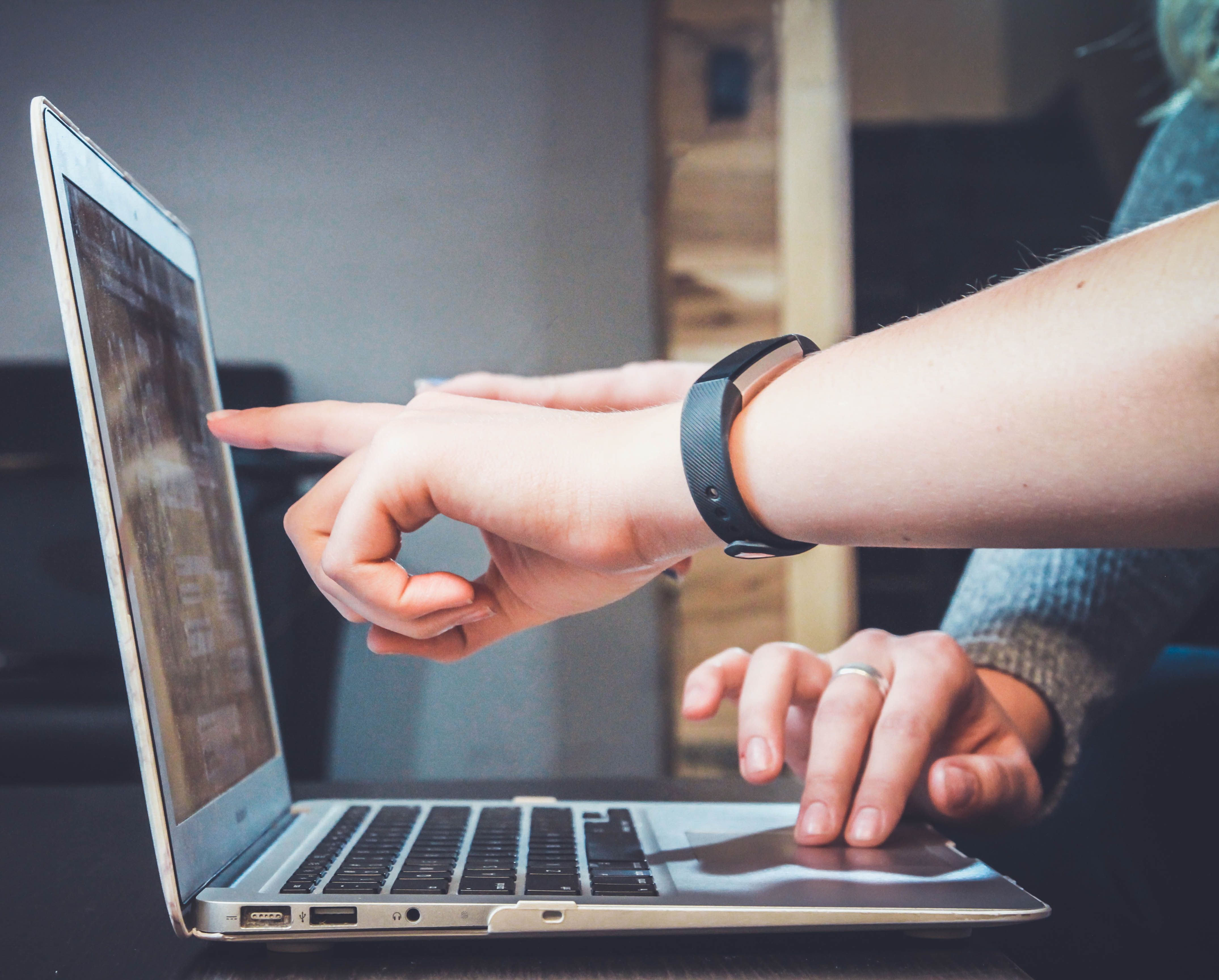 Hands pointing to the laptop monitor. 