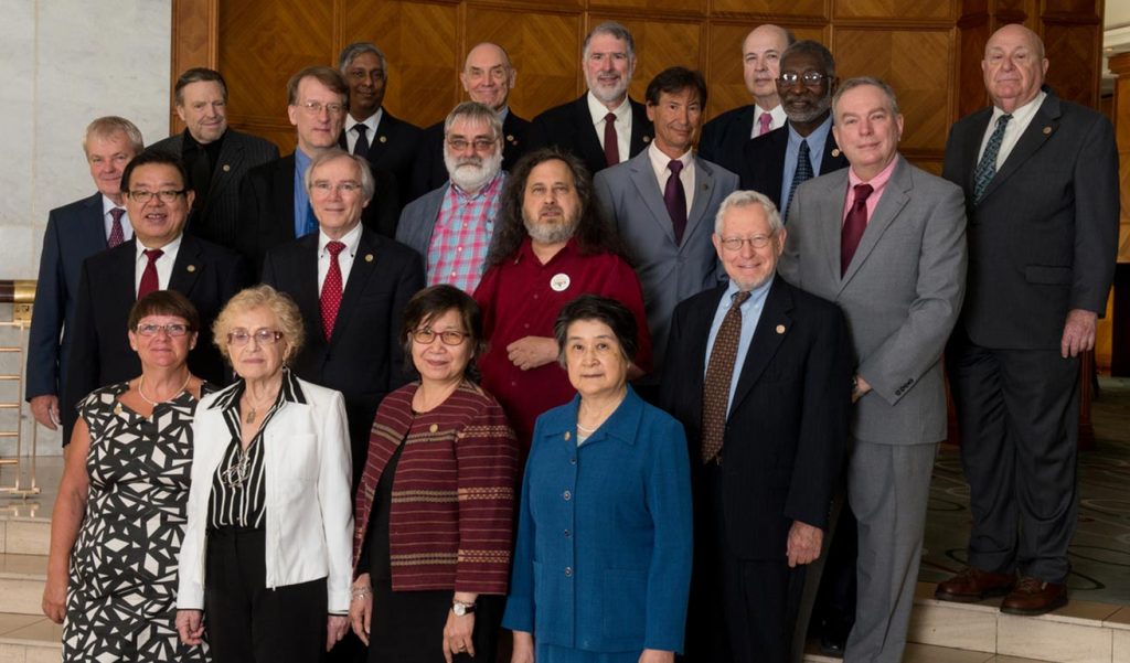 group of people standing posing for a photo in formal attire