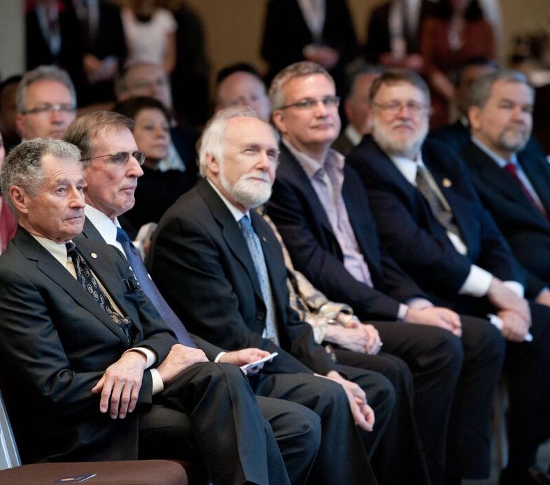 Men sitting in the first row listening