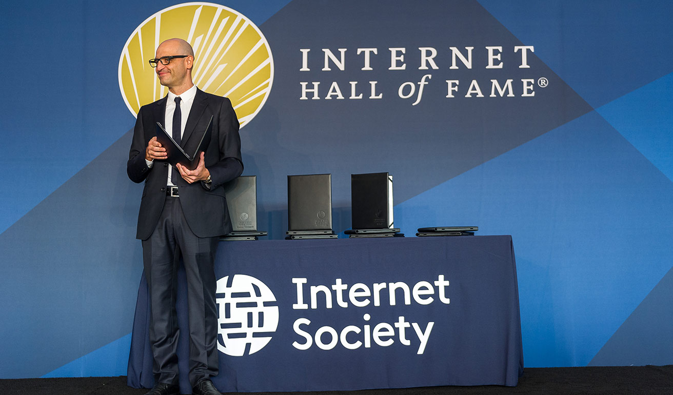 a man holding certificate award on a stage