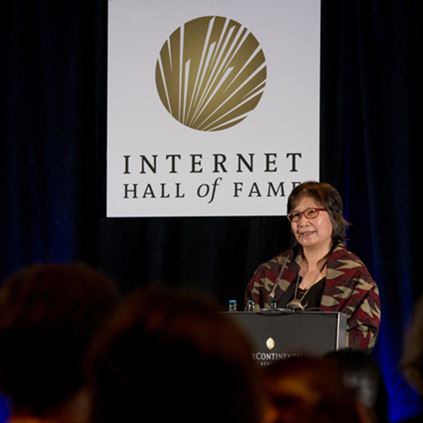 a woman stands behind podium on stage