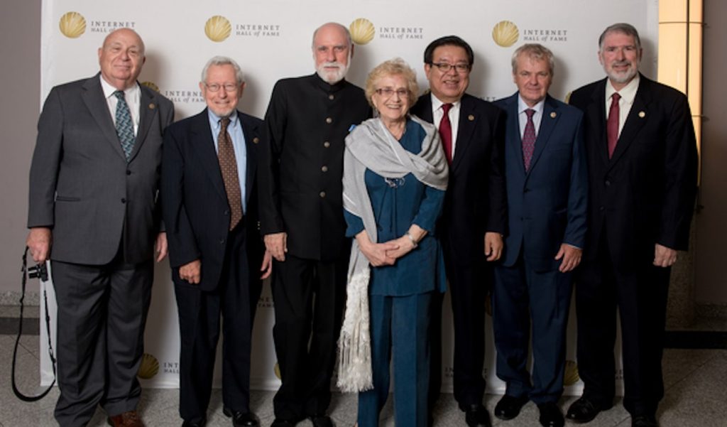 six men and a woman posing for a photo