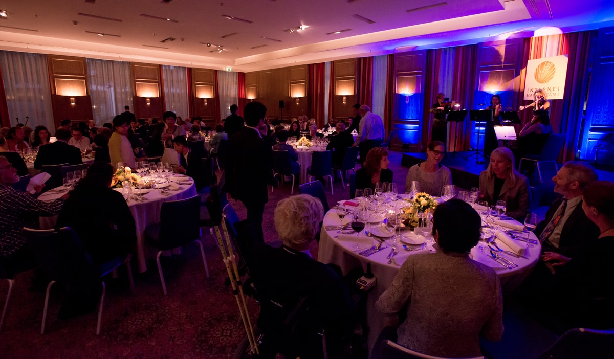 people sitting at tables in a ceremony