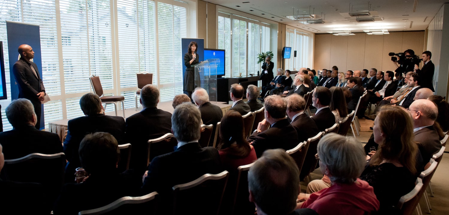 a woman on stage giving a speech in front of the audience