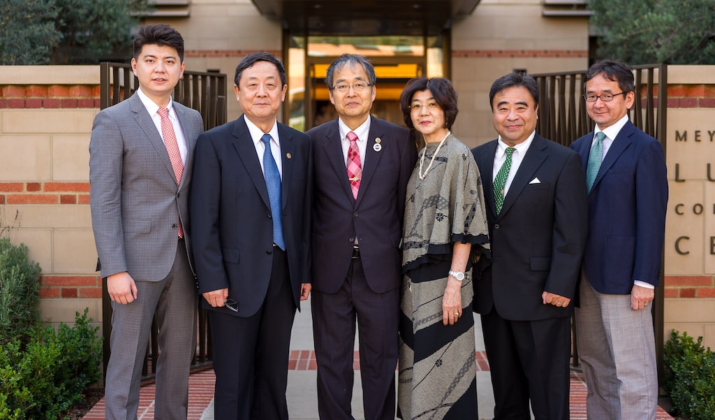 five men and a woman in formal attire posing