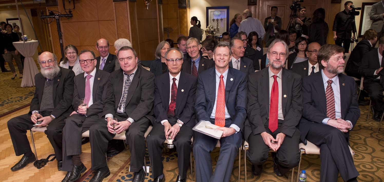 a group of people sitting in the audience smiling