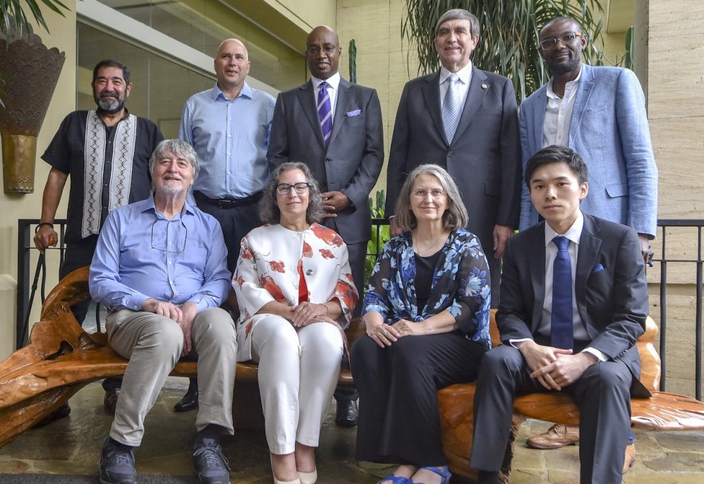 two women and seven men posing for a photo